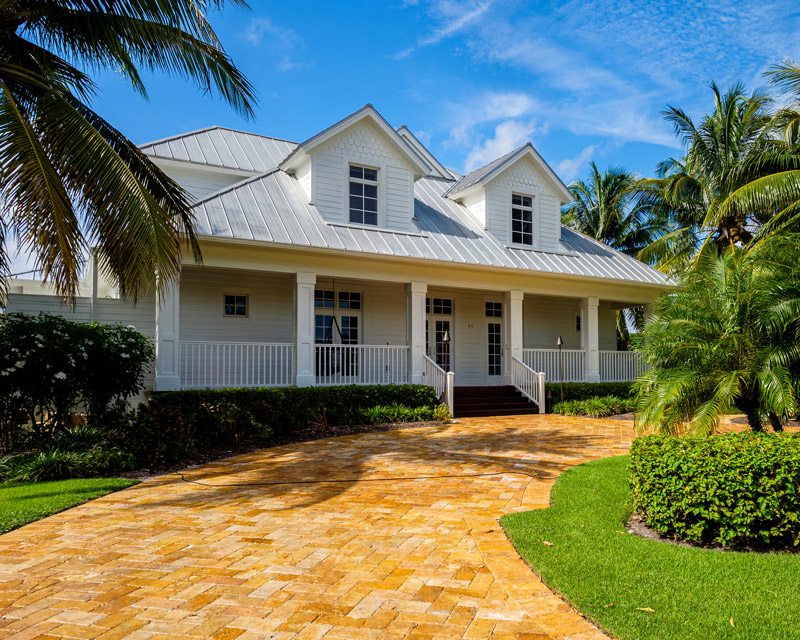 Modest white Florida house with a brick driveway